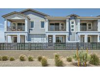 Modern townhome featuring dual balconies, gray painted siding, and xeriscaped front yard at 8149 E Petunia Ave # 1041, Mesa, AZ 85212