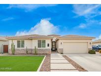 Charming single-story home featuring a well-manicured lawn, desert landscaping and a two car garage at 815 E Tucci St, San Tan Valley, AZ 85140