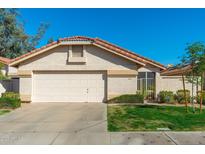 Charming single-Gathering home featuring a two-car garage and well-maintained front yard under a clear blue sky at 8812 E Riviera Dr, Scottsdale, AZ 85260