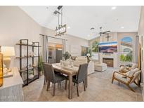 Open-concept living and dining area featuring a large TV, comfortable seating, and stylish decor at 8812 E Riviera Dr, Scottsdale, AZ 85260