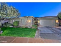 Charming single-story home with a well-manicured lawn, stone accents, and an attached two-car garage at 12859 W Calle De Baca --, Peoria, AZ 85383