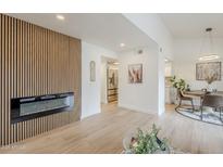 Bright living room featuring a fireplace with wood paneling and neutral decor, creating a warm and inviting atmosphere at 3102 E Clarendon Ave # 210, Phoenix, AZ 85016