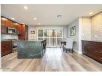 Modern kitchen with stainless steel appliances, wooden cabinets, and a large island with bar seating at 4950 N Miller Rd # 122, Scottsdale, AZ 85251