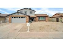 Charming two-story home featuring a well-manicured front yard and a classic brick facade at 5228 W Ironwood Dr, Glendale, AZ 85302