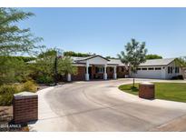 Charming brick home featuring circular driveway, basketball court, and a welcoming front porch at 5501 N 1St St, Phoenix, AZ 85012