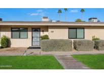 Charming single-story home featuring a secure front door and lush green lawn at 10924 W Santa Fe Dr, Sun City, AZ 85351