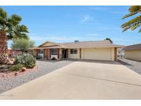 Single-story home featuring desert landscaping, a two-car garage, and a long concrete driveway at 11067 W White Mountain Rd, Sun City, AZ 85351