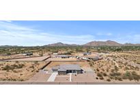 Expansive aerial view of a desert property featuring a modern home with mountain backdrop at 12204 W Blackhawk Rd, Casa Grande, AZ 85194