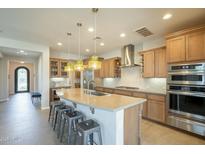 Bright kitchen with large island, stainless appliances, and pendant lighting at 1804 E Amaranth Trl, Queen Creek, AZ 85140