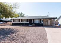 Charming single-story home featuring a stone facade, well-maintained landscaping, and a covered parking area at 2061 E Bayberry Ave, Mesa, AZ 85204