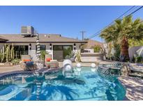 Inviting pool with spa, sun loungers, outdoor kitchen, and lush landscaping, perfect for relaxation and entertaining at 5137 E Flower St, Phoenix, AZ 85018