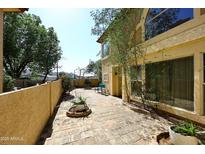 Relaxing outdoor patio with brick flooring and a stucco wall, perfect for enjoying the Arizona sunshine at 10218 N 12Th Pl # 2, Phoenix, AZ 85020