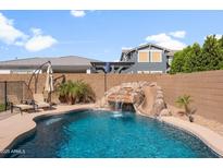 Backyard pool features a slide, waterfall and lounge chairs for relaxing and enjoying the outdoors at 10322 E Topaz Ave, Mesa, AZ 85212