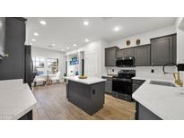 Modern kitchen with stainless steel appliances, gray cabinets, island, and breakfast nook with seating at 10942 E Sonrisa Ave, Mesa, AZ 85212