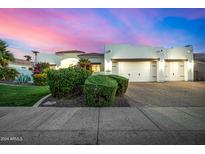 Stunning white home with a 3-car garage and beautiful desert landscaping at dusk at 11343 E Appaloosa Pl, Scottsdale, AZ 85259