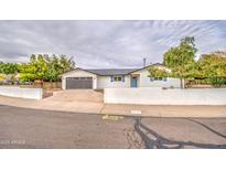 Inviting single-story home with a well-manicured front yard, attached garage, and white privacy wall at 114 E Garfield St, Tempe, AZ 85288