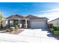 Charming single-story home featuring a neutral palette, stone accents, a well-manicured lawn, and a two-car garage at 19975 W Glenrosa Ave, Litchfield Park, AZ 85340