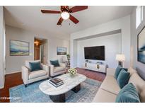 Bright living room featuring a ceiling fan, hardwood floors, and a decorative rug and furniture at 34705 N 26Th Ave, Phoenix, AZ 85086