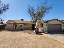 Charming single-story home featuring a unique arched entryway and low maintenance desert landscaping at 4101 E Nancy Ln, Phoenix, AZ 85042