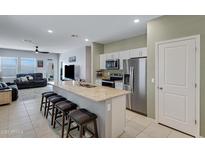 Modern kitchen featuring stainless steel appliances, granite countertops, and an island with seating at 47737 W Coe St, Maricopa, AZ 85139