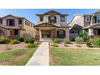 Charming two-story home featuring a stucco exterior, brown shutters, and a well-maintained landscaped front yard at 5828 E Hoover Ave, Mesa, AZ 85206