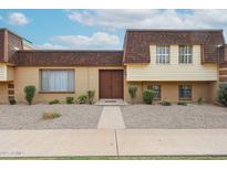 Charming two-story townhouse featuring neutral colors, double door entryway, and low-maintenance landscaping at 8442 E Chaparral Rd, Scottsdale, AZ 85250