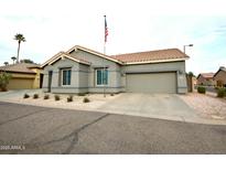 Charming single-story home with desert landscaping, a two car garage, and a flagpole with an American flag at 888 E Sheffield Ave, Chandler, AZ 85225