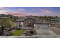 Charming home with a stone facade, arched entryway, three-car garage and desert landscaping at 9161 W Bajada Rd, Peoria, AZ 85383