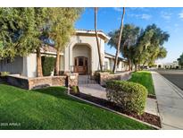 Charming home with a stone accent wall, mature trees, and manicured landscaping at 10055 E Charter Oak Rd, Scottsdale, AZ 85260
