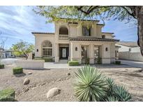 Elegant two-story home with a stucco facade, decorative wrought iron door, and desert landscaping at 7745 E Calle De Las Brisas --, Scottsdale, AZ 85255