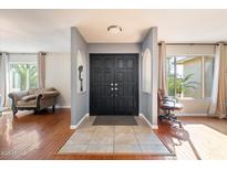 Inviting entryway featuring a modern black door, neutral walls, and warm hardwood floors at 7800 E Via Del Futuro E --, Scottsdale, AZ 85258