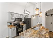 Modern kitchen featuring granite counters, stainless steel appliances, updated cabinets, and stylish pendant lighting at 974 E Palomino Way, San Tan Valley, AZ 85143