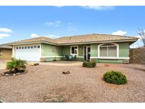 Charming single story home with a two-car garage and a cozy front patio, surrounded by low-maintenance landscaping at 11010 E Keats Ave, Mesa, AZ 85209