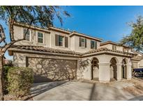 Charming two-story home featuring a neutral palette, covered entryway, two-car garage, and a classic tile roof at 11918 W Yearling Ct, Peoria, AZ 85383