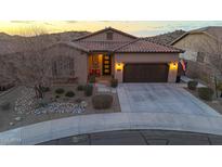 Inviting single-story home with a tile roof, desert landscaping, and an attached two-car garage at sunset at 12008 S 186Th Dr, Goodyear, AZ 85338