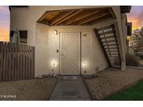 Inviting front door with unique design, complemented by warm lighting and well-maintained landscaping at 16402 N 31St St # 107, Phoenix, AZ 85032