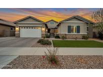 Charming single-story home featuring a two-car garage, manicured lawn, and inviting front entrance at 20102 E Robin Rd, Queen Creek, AZ 85142