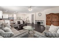 Spacious living room featuring hardwood floors, a stylish ceiling fan, and coordinated furnishings at 213 S 225Th Ln, Buckeye, AZ 85326