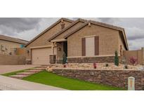 Charming single-story home boasts a well-manicured lawn, stone accents, and attached two-car garage at 2937 W Tumbleweed Dr, Phoenix, AZ 85085