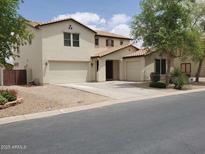Two-story home with a stucco exterior, red tile roof, three-car garage, and low-maintenance desert landscaping at 40232 W Marion May Ln, Maricopa, AZ 85138