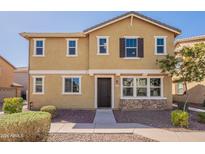 Two-story home with a combination of stucco and stone veneer, complemented by a well-maintained front yard and a paved walkway at 504 N Ranger Trl, Gilbert, AZ 85234