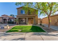 Charming two-story home boasts a well-manicured lawn and inviting curb appeal on a sunny day at 559 E Rainbow Dr, Chandler, AZ 85249