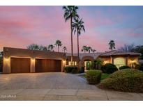 Beautiful home featuring a three-car garage, desert landscaping, and a secure gated entrance at 8924 E Charter Oak Dr, Scottsdale, AZ 85260