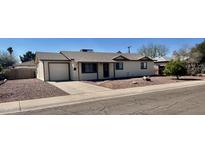 Charming single-story home featuring a well-maintained front yard with mature landscaping and a driveway at 1001 W 17Th St, Tempe, AZ 85281