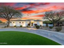 Stunning home exterior at sunset featuring a circular driveway and mature desert landscaping at 10800 E Cactus Rd # 7, Scottsdale, AZ 85259