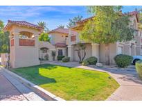 Charming townhome with a red tile roof, lush landscaping, and a well-manicured lawn at 8300 E Via De Ventura -- # 1016, Scottsdale, AZ 85258