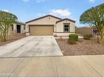 Charming single-story home with a neutral color scheme, two-car garage, and low-maintenance desert landscaping at 8886 S 256Th Dr, Buckeye, AZ 85326