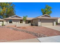 Charming single-story home with a well-maintained yard, two-car garage, and tasteful desert landscaping at 2284 Leisure World --, Mesa, AZ 85206