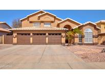 Charming two-story home featuring a three-car garage and desert landscaping at 4440 W Fallen Leaf Ln, Glendale, AZ 85310