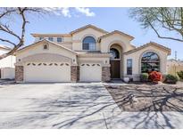 Expansive desert home featuring a 3-car garage, arched windows, neutral stucco and manicured landscaping at 7421 S 25Th Ln, Phoenix, AZ 85041